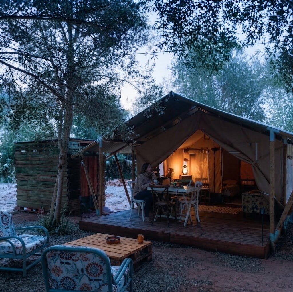 Tenda safari iluminada ao entardecer — Glamping no Norte de Portugal