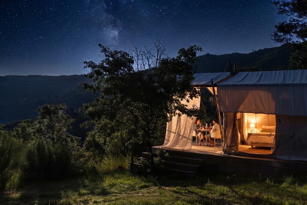 Cabana de madeira rodeada de árvores — O Que É Glamping em Portugal e Como Funciona