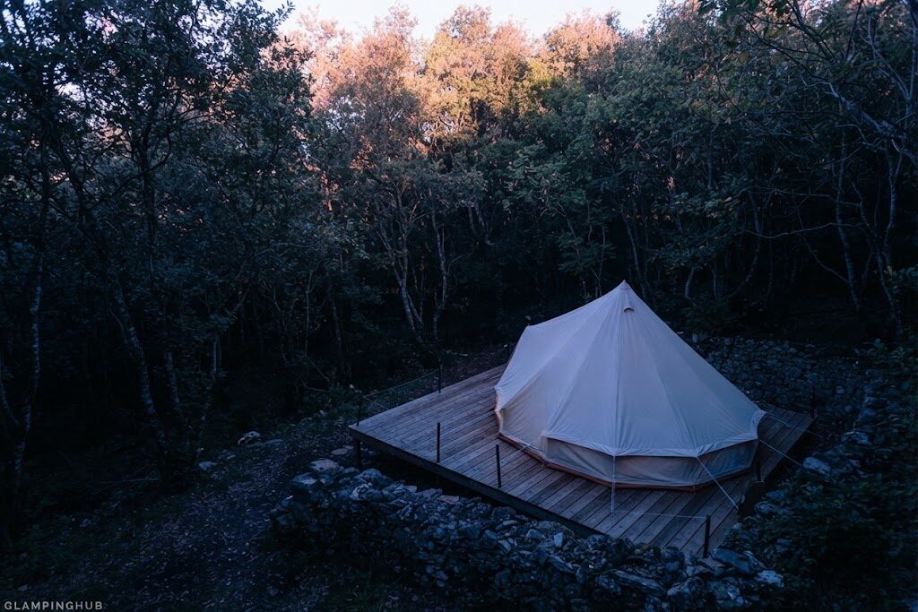 Cabana de madeira rodeada de árvores — Natura Glamping Fundão